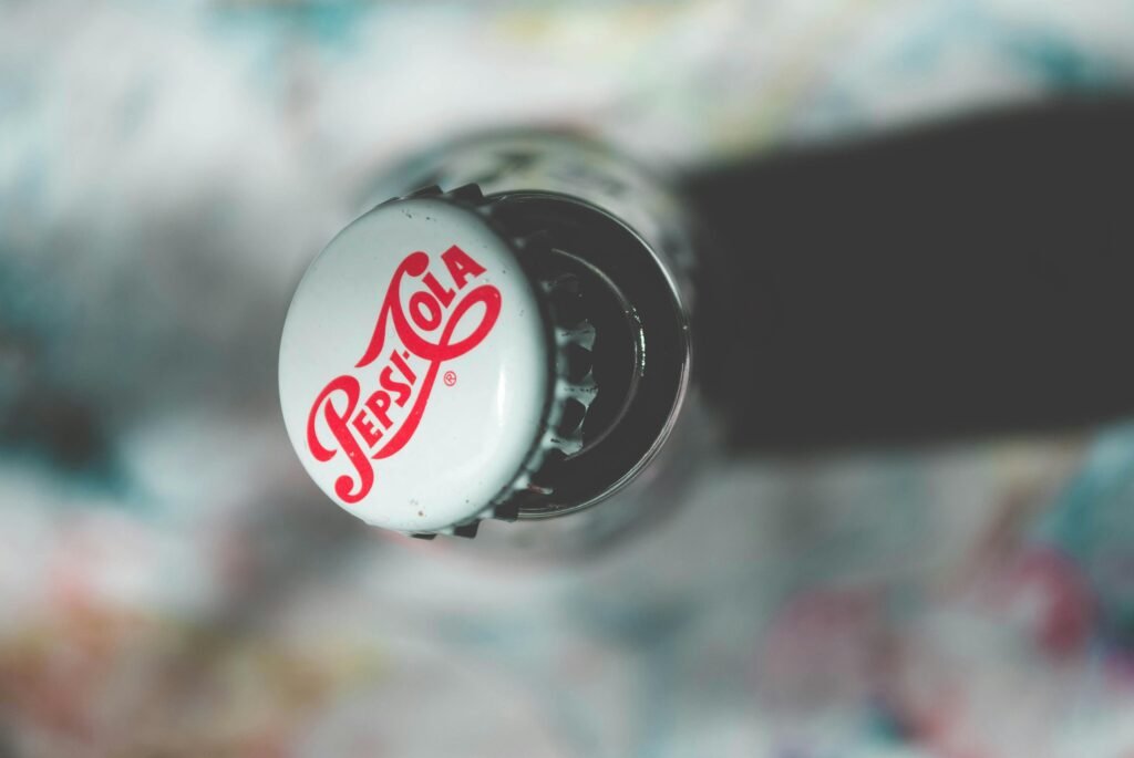 pexels-photo-988952-988952 Close-up top view of an open Pepsi Cola glass bottle showcasing its iconic branding.
